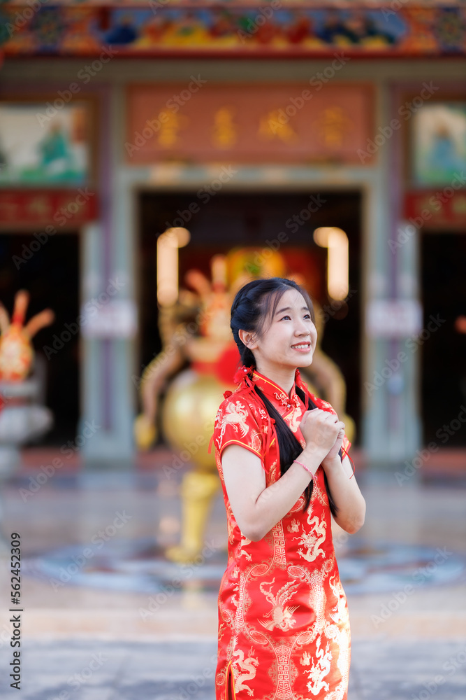 Photo Stock Portrait beautiful cute smiles Asian young woman wearing red cheongsam  dress traditional decoration for Chinese new year festival celebrate  culture of china at Chinese shrine Public places in Thailand |