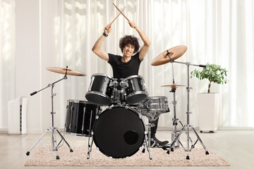 Sticker - Male drummer holding drumsticks up at home