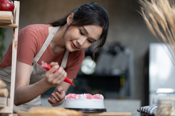 girls making a cake on the kitchen. Baker woMan Decorating Chocolate Cake with Flowers. Anonymous Female Baker Using Piping Bag to Decorate Wedding Cake.