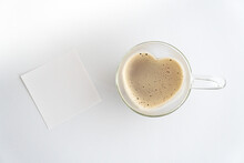 Herzförmige Tasse Aus Glas Mit Kaffee Gefüllt Vor Weißem Hintergrund, Weißer Notizzettel Blanko Daneben , Horizontal, Topview 