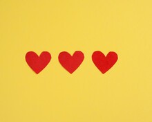 Composition Of Three Red Hearts On A Yellow Background. Flat Lay.