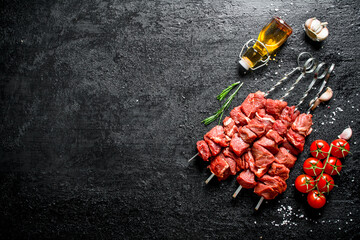 Canvas Print - Raw kebab on skewers with tomatoes, garlic and oil in a bottle.