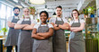 © ihorvsn - Camera approaching multi-ethnic diverse young and senior waiters in aprons stand in restaurant, looking at camera and smiling. Portrait of coffee house employees with smile on faces, business concept