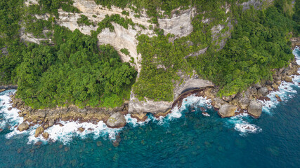 Wall Mural - Beautiful coastline aerial view from Saren Cliff Point. Clear water and rocks with cloudy sky. Nusa Penida, Indonesia.