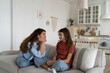 © DimaBerlin - Young loving caring mother talking with teen girl daughter while sitting on sofa in living room at home, parent spending quality time with child. Trust between parents and children
