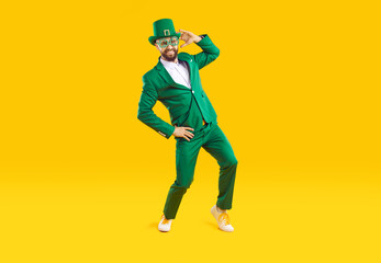 Wall Mural - happy st. patrick's day. funny stylish man in green clothes celebrates st. patrick's day on orange b