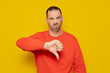 © Andres - Man in his 40s with a beard wearing red jumper looking unhappy and angry showing rejection and negative thumbs down gesture. Bad expression