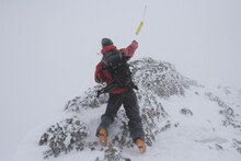 A Ski Patroller Throws A Stick Of Dynamite While On His Snow Safety Route. Ski Patrollers Throw Dynamite To Trigger Potential Av