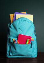 Backpack With Different School Stationery On White Table Near Chalkboard
