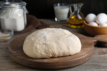 Fresh yeast dough and ingredients on wooden table