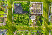 Aerial View Of The Community Based Modern Urban Farming And Organic Family Gardens With Various Vegetables, Fruits And Plants. Cultivation Of Fresh Produce And Homestead Horticulture.