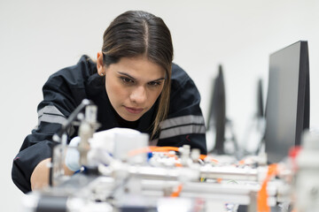 Female engineer training AI robot training kit and mechatronics engineering in the manufacturing automation and robotics academy room