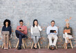 © Alexis S/peopleimages.com - Business people, line and sitting relax with technology for interview meeting, recruitment or company hiring. Human resources, employees happy and working on laptop, tablet or smartphone in studio