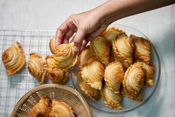 Wall Mural - Hand holding curry Puff stuffed with soybean in wicker basket