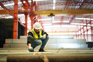 Working at warehouse. Male warehouse checking metal materials in hardware stock. goods for further placement in storage department. Employee organizing goods distribution to the market.