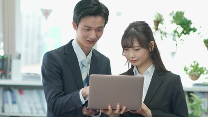 Poster - PCを見るスーツを着た若手の日本人男女