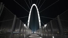 Tilt Down Wide Shot Of Urban City Metal Suspension Walking Bridge At Night