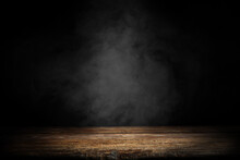 Dark Empty Wooden Table With Smoke Float Up On Dark Wall Background. Free Space For Your Decoration. 