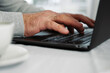 © Marina Demidiuk - Closeup of senior man hands using laptop. Cropped side view of wrinkled caucasian older hands typing keyboard. Old people with technology. Unrecognizable retired male working from home sitting at desk