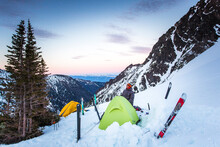 Man Standing Behind Tent Pitched In Snowy Basin At Dawn, Leavenworth, Washington, USA