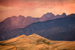 © Cavan Images - Sunset view of mountains and sand dunes.