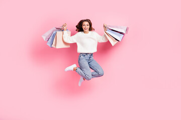 Wall Mural - Full length photo of excited lucky lady wear white sweater jumping rising shoppers isolated pink color background