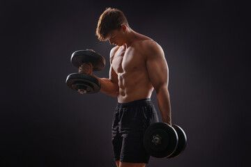 Young handsome sportsman bodybuilder weightlifter with an ideal body, after coaching poses in front of the camera, abdominal muscles, biceps triceps. In sportswear.