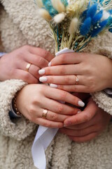 Wall Mural - Wedding rings in the hands of the bride and groom.
