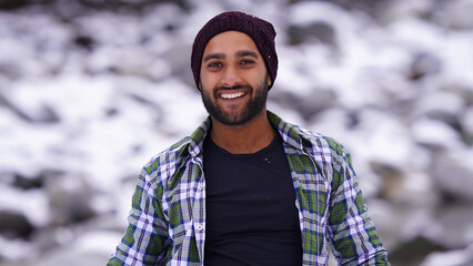 Indian boy enjoying and playing with snow during winter snowfall