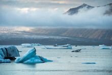 Icebergs Floating In Sea Near Mountain Range