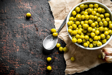 Wall Mural - Canned green peas in a bowl on paper.