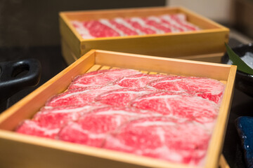 Wall Mural - Close up of premium fresh sliced meat beef and pork in each tray are prepared for cooking in a shabu-shabu hot pot or sukiyaki. Red raw meat with a beautiful white fat texture.