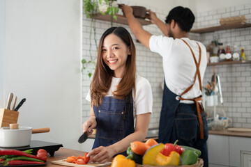 Wall Mural - Couple cooking together. Happy young couple cooking together in the kitchen. valentine day concept.