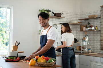 Wall Mural - Couple cooking together. Happy young couple cooking together in the kitchen. valentine day concept.