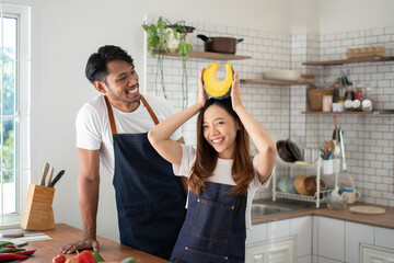 Wall Mural - Couple cooking together. Happy young couple cooking together in the kitchen. valentine day concept.