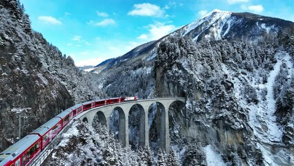 Wall Mural - Aerial view of Train passing through famous mountain in Filisur, Switzerland. Landwasser Viaduct world heritage with train express in Swiss Alps snow winter scenery. 