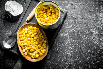 Wall Mural - Open tin can with canned corn on the cutting Board.
