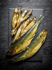 Canvas Print - Different smoked fish on a stone Board.