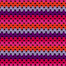 Bright Seamless Knitted Texture. The Pattern Is Crocheted From Multi-colored Acrylic Yarn. Zigzag Shapes. African Motives. 