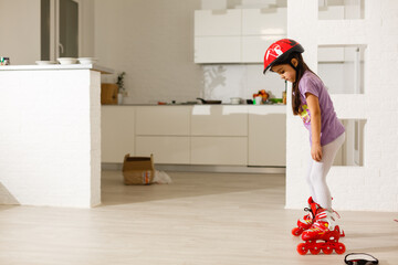 Caucasian little girl in roller skates standing at the living room