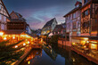 Traditional half-timbered houses and restaurants on river bank in Colmar at twilight , Alsace rigion, France