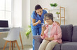 © Studio Romantic - Friendly young nurse teaches older female patient how to download health app on her mobile phone. Smiling caregiver and senior woman in nursing home looking at mobile phone screen together.