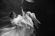 © evdokimari - Young beautifull caucasian woman in dress under water in black and white