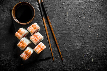 Poster - Fresh sushi rolls with shrimp on a stand with soy sauce and chopsticks.