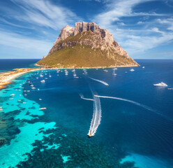 Sticker - Aerial view of luxury yachts and boats on blue sea, beautiful mountain and sky with clouds at summer sunny day. Sandy beach on Tavolara island in Sardinia, Italy. Top view. Colorful seascape. Travel