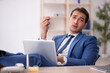 © Elnur - Young male employee working in the office