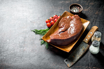 Sticker - Piece of raw liver on a plate with a knife, spices and tomatoes on a branch.