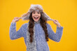 © Olena - Beautiful winter kids portrait. Teenager girl posing with winter sweater and knit hat on yellow background. Excited teenager girl.