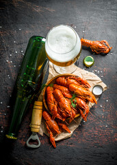 Poster - Red boiled crayfish in a plate on paper with beer in a glass and bottle.