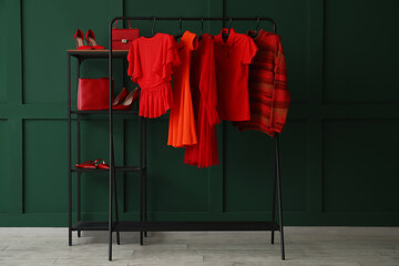 Wall Mural - Rack with red clothes, shelving unit and shoes near green wall